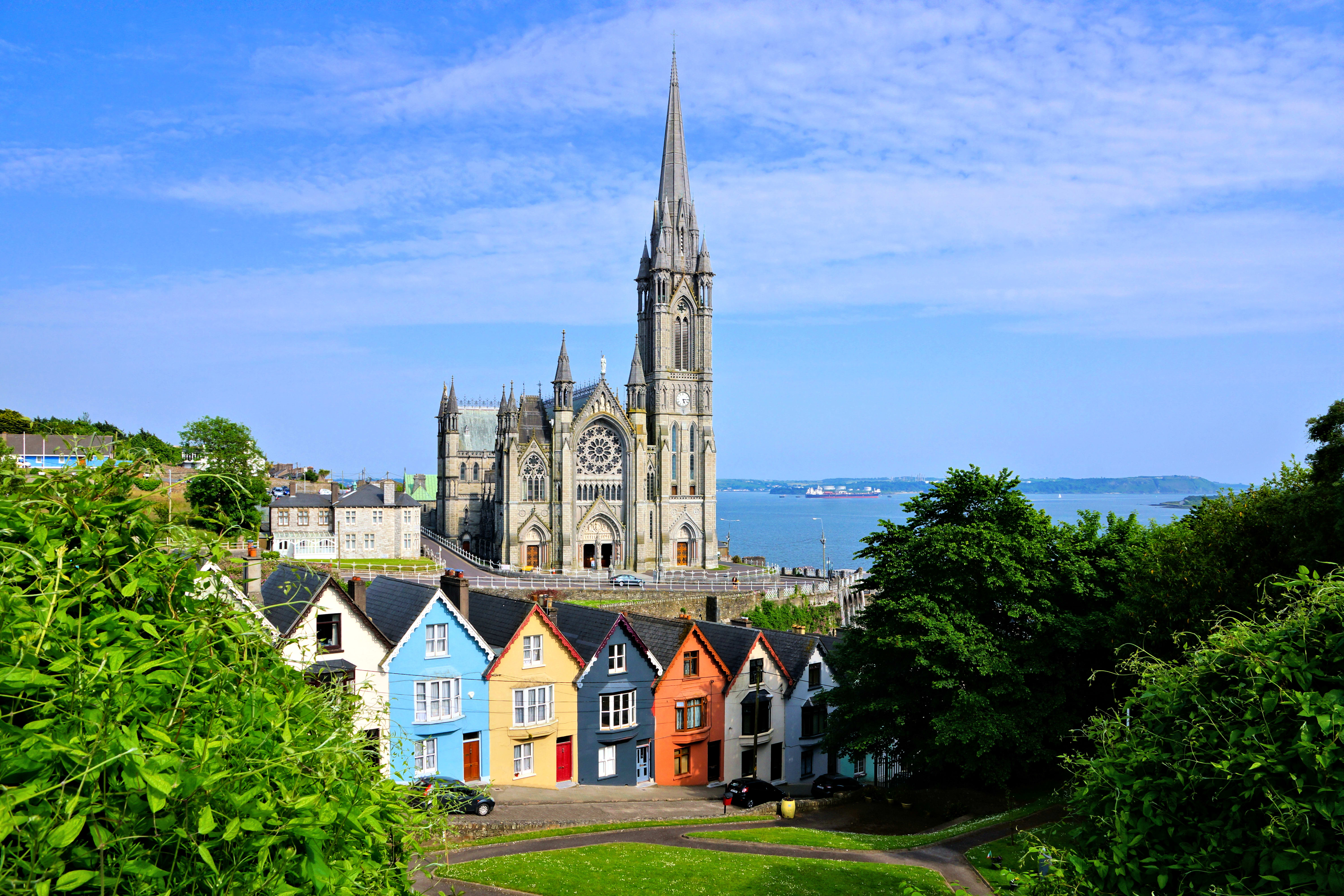 Colourful row houses with towering cathedral in background in the port town of Cobh